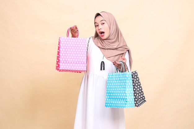 il fascino di una giovane donna musulmana indonesiana che indossa un hijab è sorpreso di portare un pappa colorato