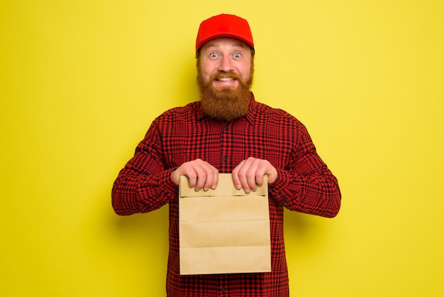 Il fattorino con cappello e barba ha un'espressione felice