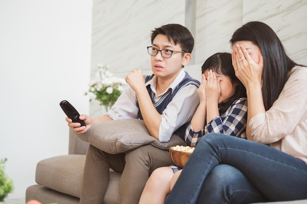 Il felice stile di vita della famiglia asiatica si diverte a guardare i film spaventosi della TV a casa