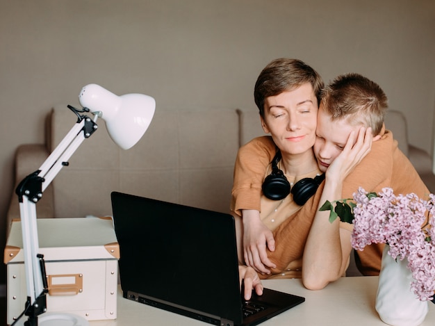 Il figlio del figlio abbraccia la mamma che lavora a casa online