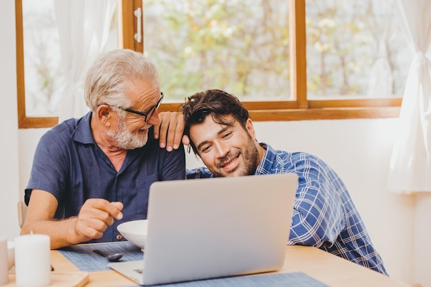 Il figlio e l'anziano padre felice momento insieme guardando il laptop per una buona memoria