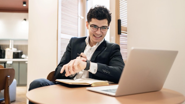 Il finanziere nell'ufficio di lavoro degli occhiali utilizza un laptop scrive una risposta al rapporto aziendale del cliente