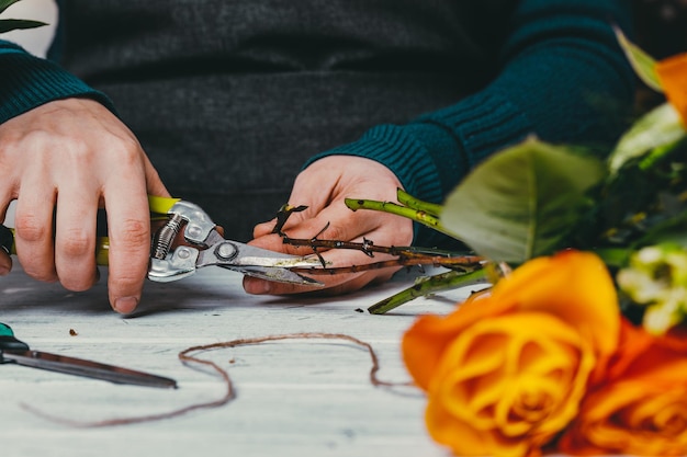 Il fiorista al lavoro realizza un moderno bouquet alla moda di fiori diversi