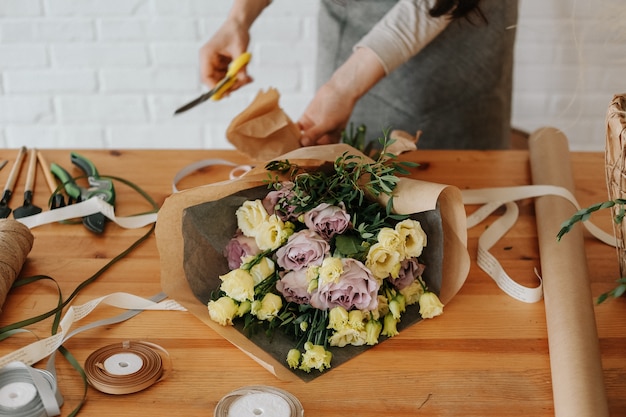 Il fiorista della donna raccoglie il mazzo decora i fiori differenti