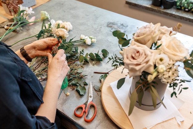 Il fiorista prepara fiori e piante per creare un bouquet insolito per le vacanze.