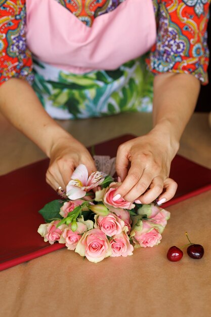 Il fiorista realizza un insolito bouquet di rose e ciliegie