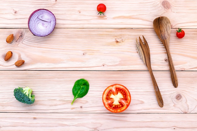 Il fondo dell&#39;alimento e il concetto dell&#39;insalata con il piano crudo degli ingredienti mettono sul fondo di legno bianco.