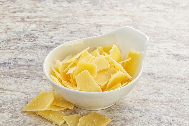 Il formaggio parmigiano tagliato in fette viene messo in una ciotola per essere servito e cucinato