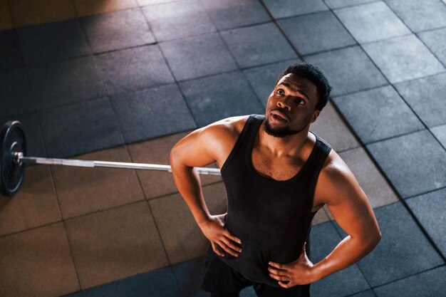 Il forte uomo afroamericano in abiti sportivi ha una giornata di allenamento in palestra