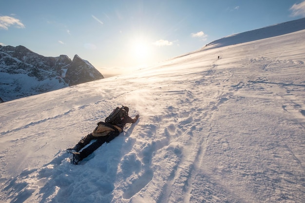 Il fotografo dell'uomo si sta arrampicando sulla collina innevata nella bufera di neve