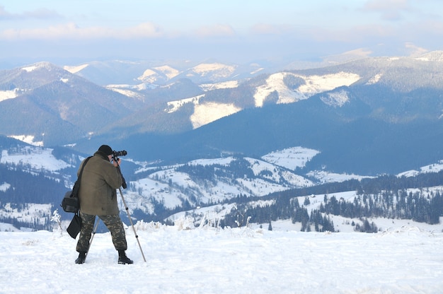 Il fotografo scatta foto dalla cima della montagna