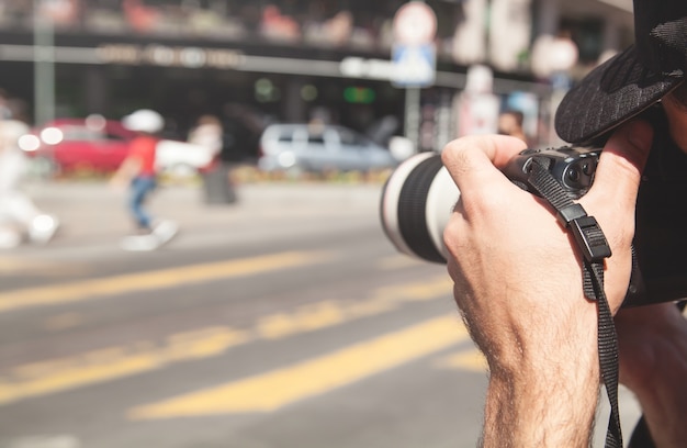Il fotografo scatta fotografie con la fotocamera reflex digitale in una città.