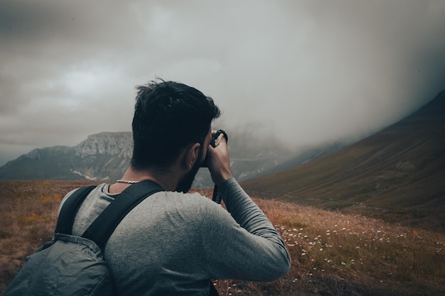 Il fotografo sulla montagna scatta una foto