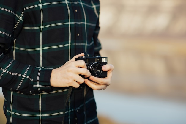 Il fotografo tiene la retro macchina fotografica nelle mani