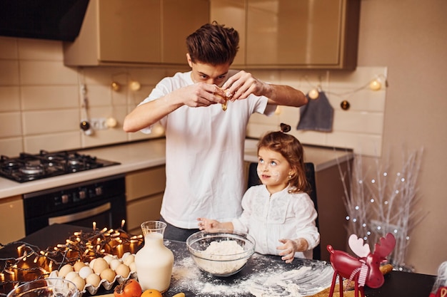 Il fratello con la sua sorellina prepara il cibo in cucina e si diverte.