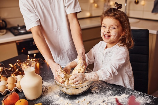 Il fratello con la sua sorellina prepara il cibo in cucina e si diverte.