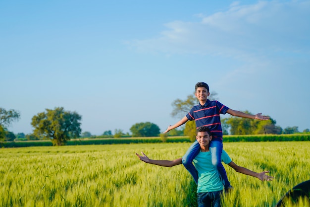 Il fratello trasporta sulle spalle suo fratello piccolo nel campo di frumento, India rurale