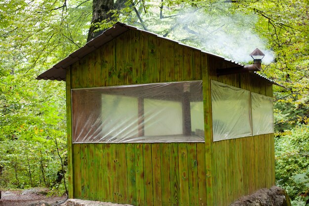 il fumo esce da una casa di legno nella foresta