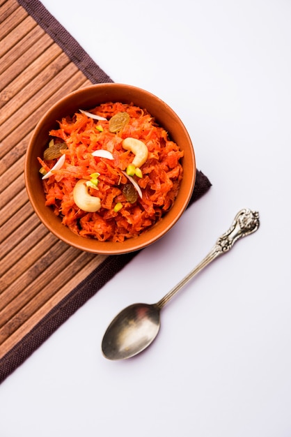 Il Gajar ka halwa è un budino dolce a base di carote proveniente dall'India. Guarnito con mandorle di anacardi. servito in una ciotola.