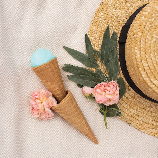 Il gelato blu in una cialda a cono si trova vicino a un cappello di paglia