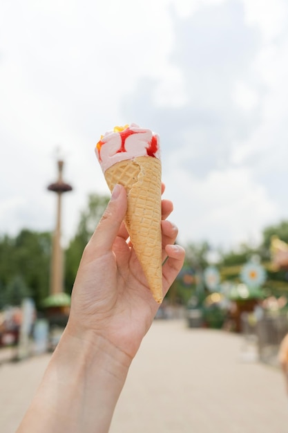 Il gelato è tenuto dalla mano di una donna, in una soleggiata giornata estiva