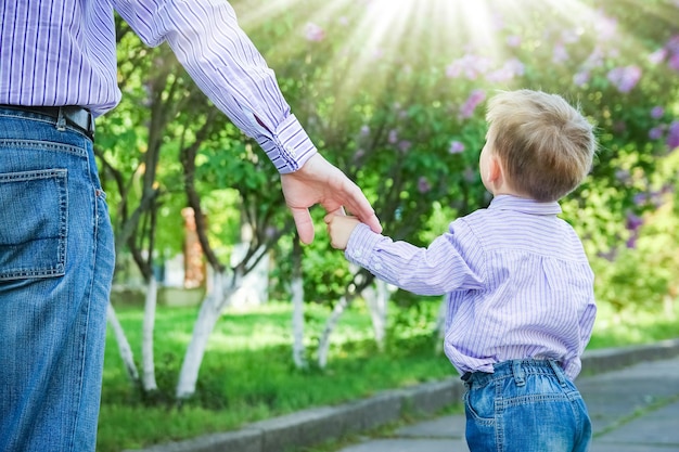 Il genitore che tiene la mano del bambino con uno sfondo felice