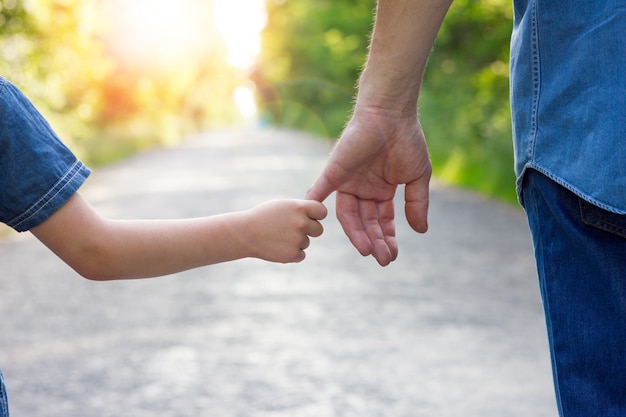 il genitore tiene la mano di un bambino piccolo