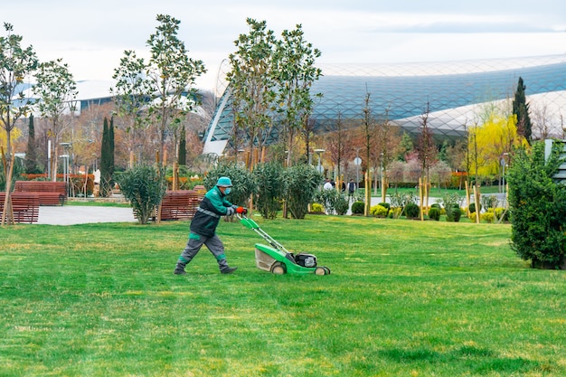 Il giardiniere che taglia l'erba con il tosaerba