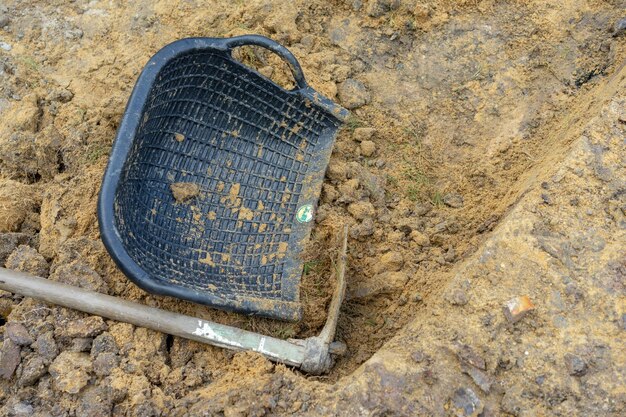 Il giardiniere scava il terreno con la sua attrezzatura per il giardinaggio e prepara il terreno per la piantagione.