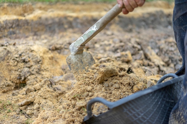 Il giardiniere scava il terreno con la sua attrezzatura per il giardinaggio e prepara il terreno per la piantagione