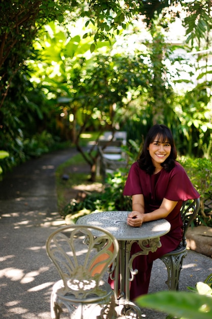 Il giardino forestale in abito viola donna indiana si rilassa il concetto di stile. I capelli corti neri asiatici degli anni '20 si sentono felici nella fattoria di bambù verde. La donna resta calma nell'ambiente naturale estivo