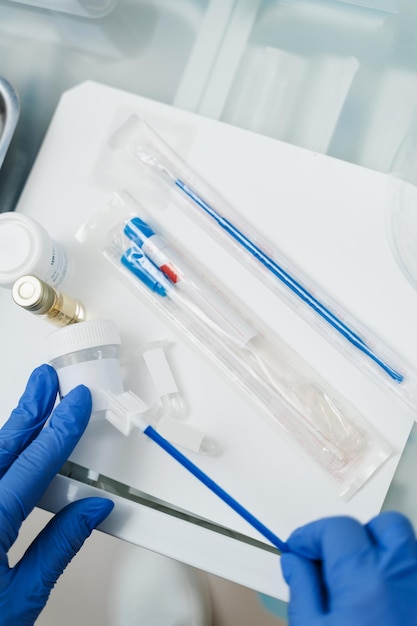 Il ginecologo tiene in mano la boccetta per la citologia Pap test test Citologia ginecologica Pap test test e cytobrush nelle mani del ginecologo