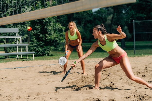 Il giocatore di beach tennis colpisce la palla