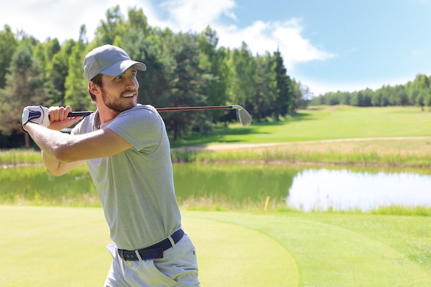 Il giocatore di golf colpisce un fairway shot verso la club house.