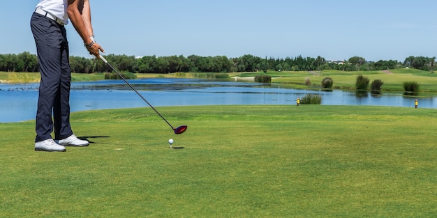 Il giocatore di golf maschio ha colpito la palla con il bastone