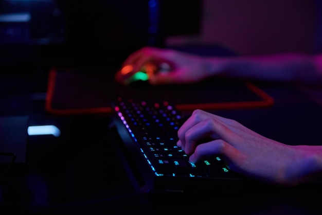 Il giocatore professionista gioca al videogioco per computer in una stanza buia