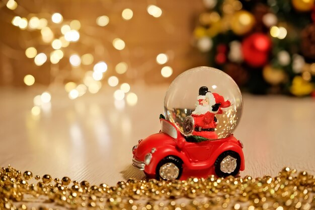 Il giocattolo di Capodanno Babbo Natale sta guidando una ciotola di vetro per auto