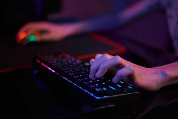 Il gioco per computer del giocatore utilizza la tastiera colorata al neon rgb