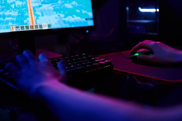 Il gioco per computer del giocatore utilizza la tastiera colorata al neon rgb