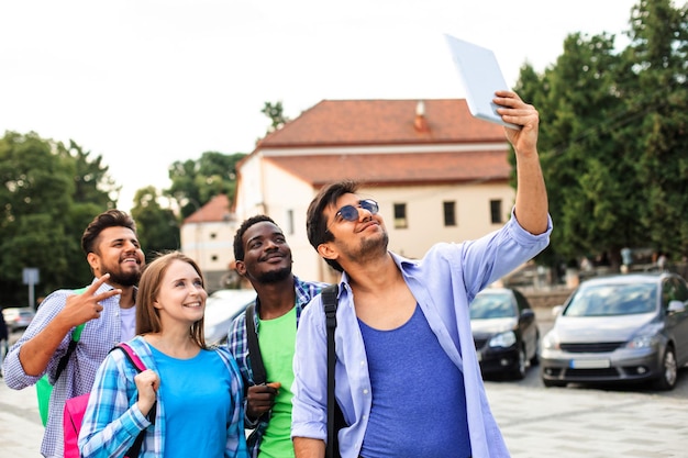 Il gioioso gruppo di studenti multietnici che si fanno un selfie all'aperto