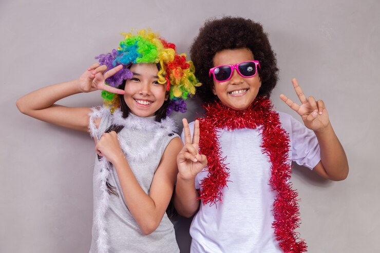 Il giorno dei bambini concetto. Due bambini, un ragazzo afro e una ragazza asiatica in abiti colorati, festeggiano