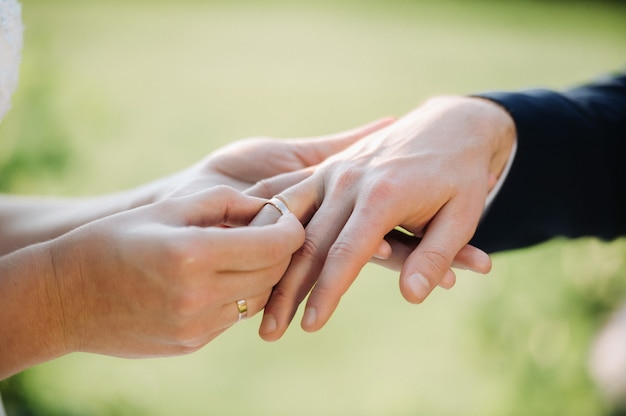 Il giorno del matrimonio, la sposa mette un anello di fidanzamento al dito dello sposo.