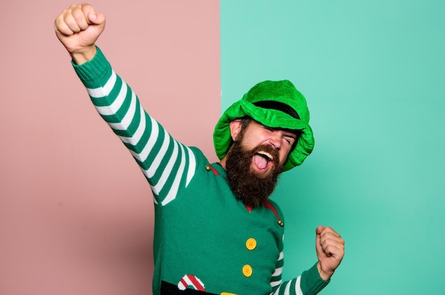 Il giorno di San Patrizio Hipster con la barba che indossa un costume verde per la festa Uomo allegro celebrare le vacanze Elfo di Natale Concetto di elfo Tradizioni o costumi Felice celebrazione Elfo barbuto Carnevale invernale