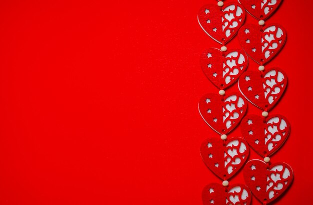 Il giorno di San Valentino concetto. Cuori rossi tessili su sfondo rosso, posto per il testo.