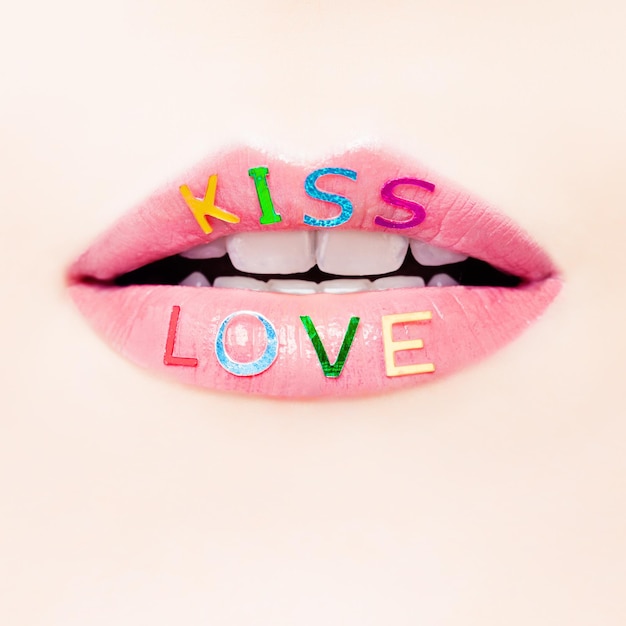 Il giorno di San Valentino e il concetto di amore con belle labbra femminili primo piano Sorriso femminile perfetto con trucco rossetto glitterato e segno d'amore
