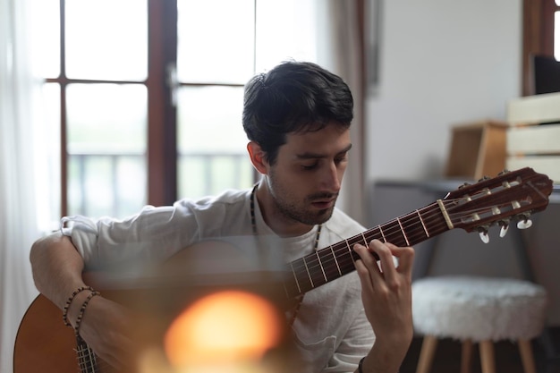 Il giovane adulto suona la chitarra nella sua camera da letto