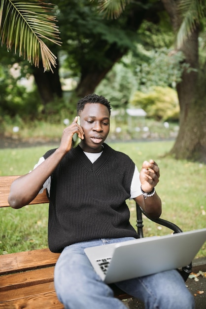 Il giovane africano che parla al telefono discutendo sul computer ha sottolineato insoddisfatto