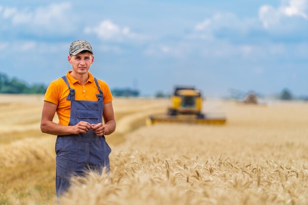 Il giovane agricoltore sta incrociando le mani nel campo dell'oro. Operaio agricolo professionale al lavoro.