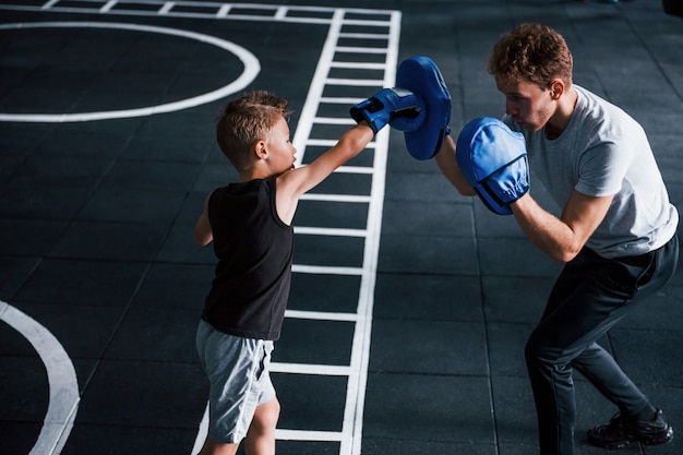 Il giovane allenatore insegna sport di boxe per bambini in palestra.