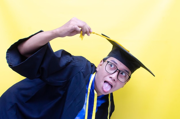 il giovane asiatico scioccato e sorpreso grida felicemente per celebrare la sua laurea